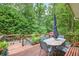 View of deck featuring an outdoor dining set and lush greenery at 505 Armor Knl, Powder Springs, GA 30127