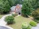 Beautiful brick home featuring a well-manicured lawn, mature trees, and a two-car garage at 505 Armor Knl, Powder Springs, GA 30127