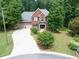 Aerial front view of a two-story brick home with a landscaped yard and a three car driveway at 505 Armor Knl, Powder Springs, GA 30127