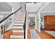 Open foyer featuring hardwood floors, a staircase with black and white railings, and ample natural light at 505 Armor Knl, Powder Springs, GA 30127