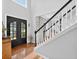 Bright foyer showcasing hardwood floors, a striking staircase, and an elegant black front door at 505 Armor Knl, Powder Springs, GA 30127