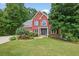 Charming two-story red brick home with black shutters, lush landscaping, and a well-manicured lawn at 505 Armor Knl, Powder Springs, GA 30127