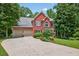 Red brick home with attached garage, lush landscaping, well-manicured lawn, and a classic architectural design at 505 Armor Knl, Powder Springs, GA 30127