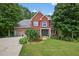 Charming two-story red brick home with black shutters, lush landscaping, and a well-manicured lawn at 505 Armor Knl, Powder Springs, GA 30127