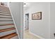 Well lit hallway with hardwood stairs and trim, neutral walls and a decorative carpet at 505 Armor Knl, Powder Springs, GA 30127