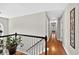 Upstairs hallway features hardwood floors and decorative wall art leading to several bedrooms at 505 Armor Knl, Powder Springs, GA 30127