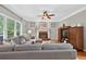 Comfortable living room with gray sofa, brick fireplace, ceiling fan, and lots of natural light at 505 Armor Knl, Powder Springs, GA 30127