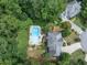 Aerial view of house with backyard in-ground pool, lounge chairs, patio furniture, and lots of trees at 505 Armor Knl, Powder Springs, GA 30127