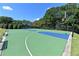 Outdoor basketball court with green surface, blue accents, and surrounding trees for recreation at 5347 Harbury Cv, Suwanee, GA 30024