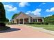 Attractive brick clubhouse featuring a covered entrance, brick columns, and manicured landscaping at 5347 Harbury Cv, Suwanee, GA 30024
