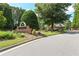 Community entrance sign with brick base, landscaping, and a glimpse of the homes within at 5347 Harbury Cv, Suwanee, GA 30024