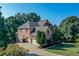 Charming brick home featuring a three-car garage and mature trees at 5347 Harbury Cv, Suwanee, GA 30024