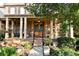 Inviting front porch with columns, double doors, and professionally landscaped garden at 5347 Harbury Cv, Suwanee, GA 30024