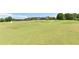 Expansive golf course with lush green fairways and a view of the residential building in the distance at 5347 Harbury Cv, Suwanee, GA 30024