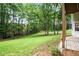 Landscaped backyard has tall trees and is very green, with access to under deck patio at 6380 Bannerhorn Run, Alpharetta, GA 30005