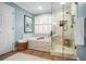 Beautiful bathroom features a soaking tub, glass shower, and neutral color palette at 6380 Bannerhorn Run, Alpharetta, GA 30005