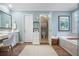 Tranquil bathroom with a soaking tub, vanity, and separate toilet room featuring soft colors and natural light at 6380 Bannerhorn Run, Alpharetta, GA 30005