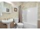 Bright bathroom features a pedestal sink, toilet, and shower/tub combo with neutral decor at 6380 Bannerhorn Run, Alpharetta, GA 30005