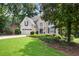 Beautifully landscaped front yard and exterior of a charming two-story home, featuring an attached garage at 6380 Bannerhorn Run, Alpharetta, GA 30005