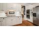Charming kitchen features stainless appliances, white cabinets, subway tile backsplash, and hardwood floors at 6380 Bannerhorn Run, Alpharetta, GA 30005