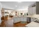 Bright, eat-in kitchen flows into the living room with fireplace and features stainless appliances and white cabinetry at 6380 Bannerhorn Run, Alpharetta, GA 30005