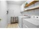 Functional laundry room with washer, dryer, storage shelves, and organization for efficient chores at 6380 Bannerhorn Run, Alpharetta, GA 30005