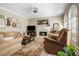 Cozy living room featuring a fireplace, plush seating and large windows with natural light at 6380 Bannerhorn Run, Alpharetta, GA 30005