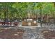 Outdoor grilling area with charcoal grill and table seating among mature trees and gravel at 840 United Se Ave # 205, Atlanta, GA 30312
