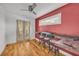 Bonus room featuring hardwood floors, double doors, desk with bar stools, red accent wall, and natural light at 183 Cleveland # B, Atlanta, GA 30316