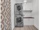 Bright laundry area includes stacked washer/dryer, white cabinets, gray vinyl floors, and stylish patterned privacy curtain at 183 Cleveland # B, Atlanta, GA 30316