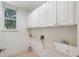 The laundry room offers practical storage with upper cabinets and a utility sink, enhancing functionality at 2956 Nestle Creek Dr, Marietta, GA 30062