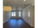 Open-concept living room with hardwood floors, large windows, and modern ceiling fan at 5099 Noble Village Way, Lilburn, GA 30047