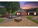 Backyard view of exterior of the home with fire pit, deck and lush landscaping at dusk at 2631 Young Rd, Stone Mountain, GA 30088