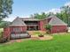 Exterior view of the backyard and home with deck, fire pit, manicured lawn and mature trees at 2631 Young Rd, Stone Mountain, GA 30088