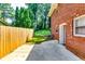 Side yard featuring a concrete patio, wooden fence, and access to a grassy backyard at 516 Jordan Nw Dr, Tucker, GA 30084
