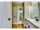 Long, bright bathroom with white sink, black hardware, wood look floors, and view to bedroom at 516 Jordan Nw Dr, Tucker, GA 30084