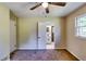 Carpeted bedroom with ceiling fan, closet, window with natural light, and view to bathroom at 516 Jordan Nw Dr, Tucker, GA 30084