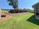 Green backyard with a retaining wall and garden, offering a private outdoor retreat at 5290 Hidden Valley Ln, Cumming, GA 30028