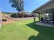 Landscaped backyard with green lawn and a covered patio featuring an outdoor dining set and grill at 5290 Hidden Valley Ln, Cumming, GA 30028