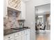 Home wet bar with wine rack, subway tile backsplash, and dark countertops at 5290 Hidden Valley Ln, Cumming, GA 30028
