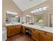 Bathroom featuring double vanity sinks, wood cabinets, and a window providing natural light at 1520 Dorchester Dr, Lawrenceville, GA 30043