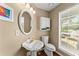 Neutral bathroom with pedestal sink, toilet, cabinet and window at 1520 Dorchester Dr, Lawrenceville, GA 30043