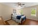 Cozy bedroom with hardwood floors, ceiling fan, a queen-sized bed, and windows offering natural light at 1520 Dorchester Dr, Lawrenceville, GA 30043