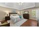 Spacious main bedroom with tray ceiling, wood floors, and ensuite bathroom at 1520 Dorchester Dr, Lawrenceville, GA 30043