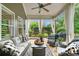 Inviting covered patio featuring comfortable seating, ceiling fan, and view of landscaped backyard at 4875 Churchill Ridge Dr, Cumming, GA 30028