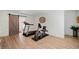 Beautiful exercise room with wood floors, home gym equipment and rustic sliding door at 4875 Churchill Ridge Dr, Cumming, GA 30028