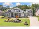 Charming home featuring professionally landscaped front yard with lush green grass and flower bed at 4875 Churchill Ridge Dr, Cumming, GA 30028