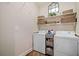 Functional laundry room with white washer and dryer and wire shelves at 4875 Churchill Ridge Dr, Cumming, GA 30028