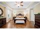 Main bedroom with tray ceilings, hardwood floors, and a sitting area with a view of the backyard at 4875 Churchill Ridge Dr, Cumming, GA 30028