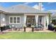 Spacious backyard with a stone patio, dining and seating areas, flower pots, and a built-in grill at 4875 Churchill Ridge Dr, Cumming, GA 30028